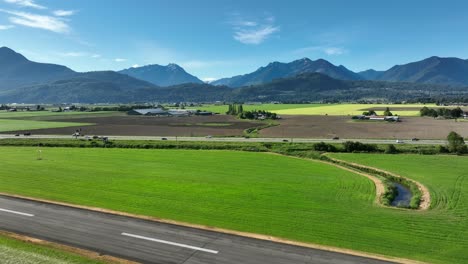 tráfico sobre la autopista cerca del aeropuerto de chiliwack con el valle de fraser en el fondo en columbia británica, canadá