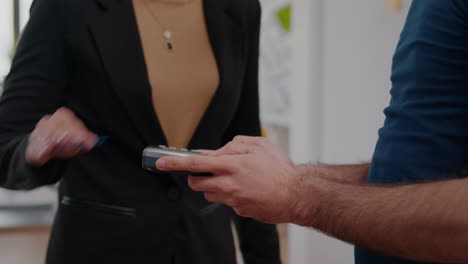 closeup of businesswoman paying delivery food order with credit card using contactless