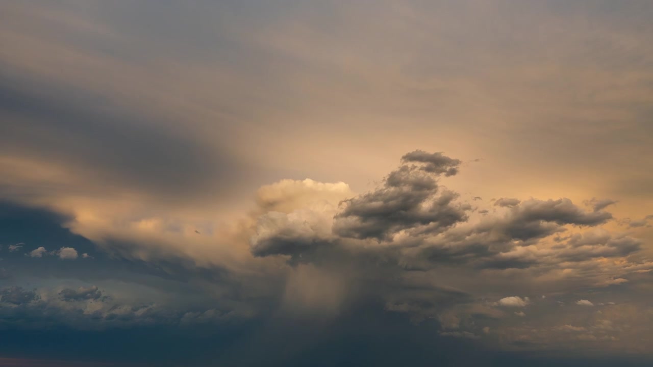Fiery golden clouds drifting through a dramatic sunset evening sky