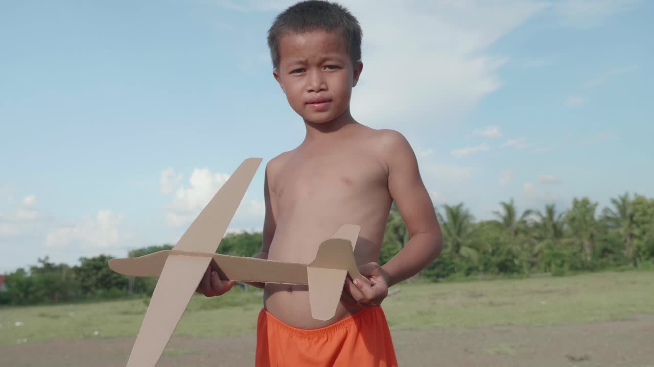 Boy Playing with Cardboard Airplane