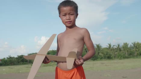boy playing with cardboard airplane