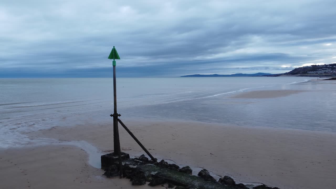 변덕스러운 흐린 썰물 해변을 가로지르는 해안 조수 마커 조감도 저궤도