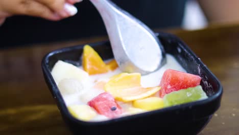 colorful fruit dessert being prepared and enjoyed