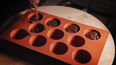 pouring choco banana cake mixture into mold using spoon