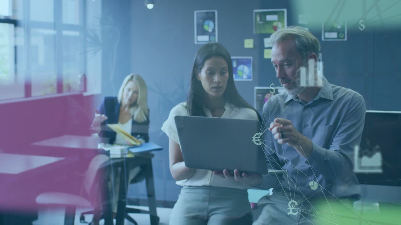 Woman holding laptop, man gesturing and tracing charts appearing on glass, analyzing business data
