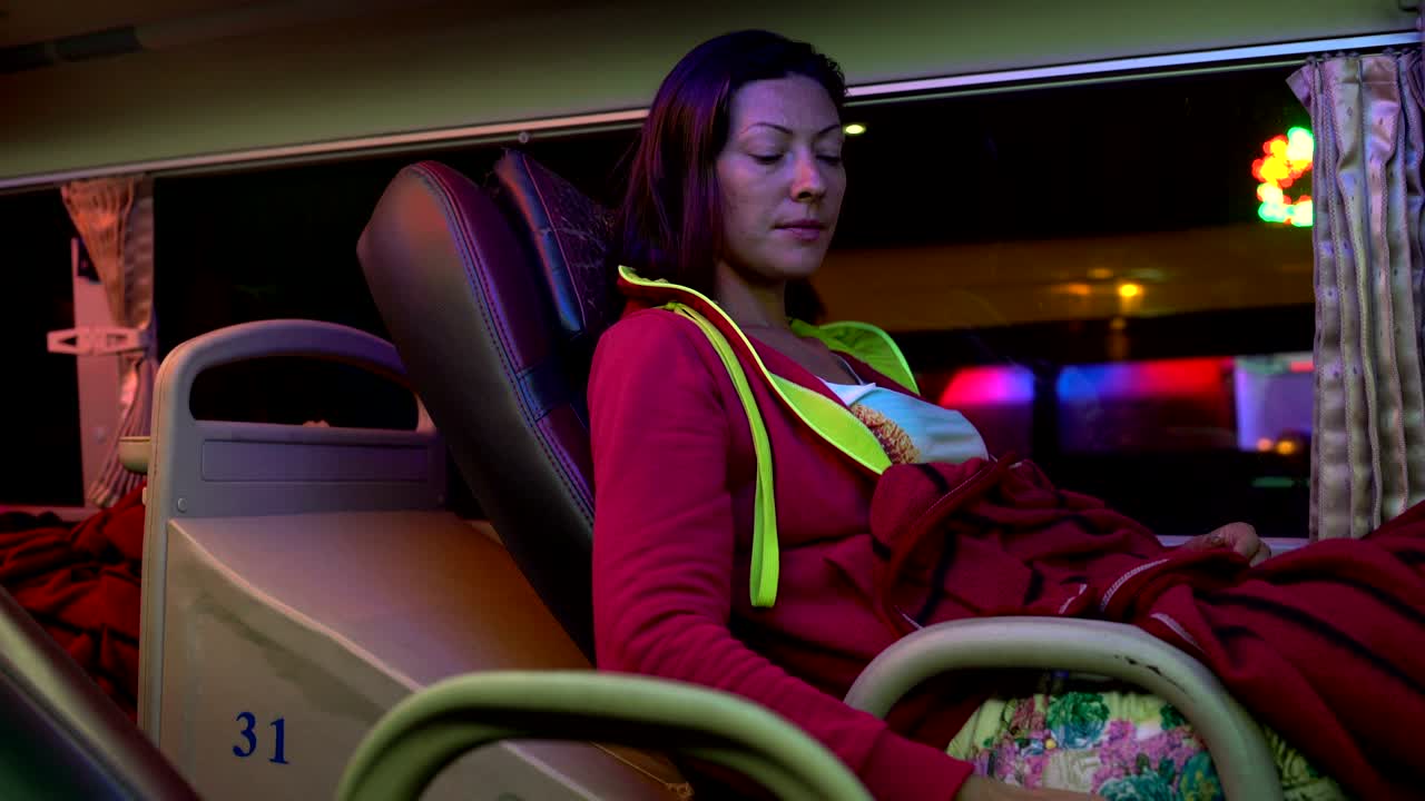 한 여자 가 잠자리 버스 의 좌석 을 뒤로 던진다