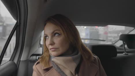 mujer mirando por la ventana del coche bajo la lluvia