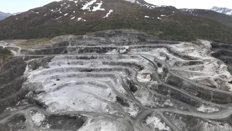 mountainside totally damaged by mining activities at visnes kalk between molde and kristiansand in norway - roads and carved out patterns in destroyed mountain