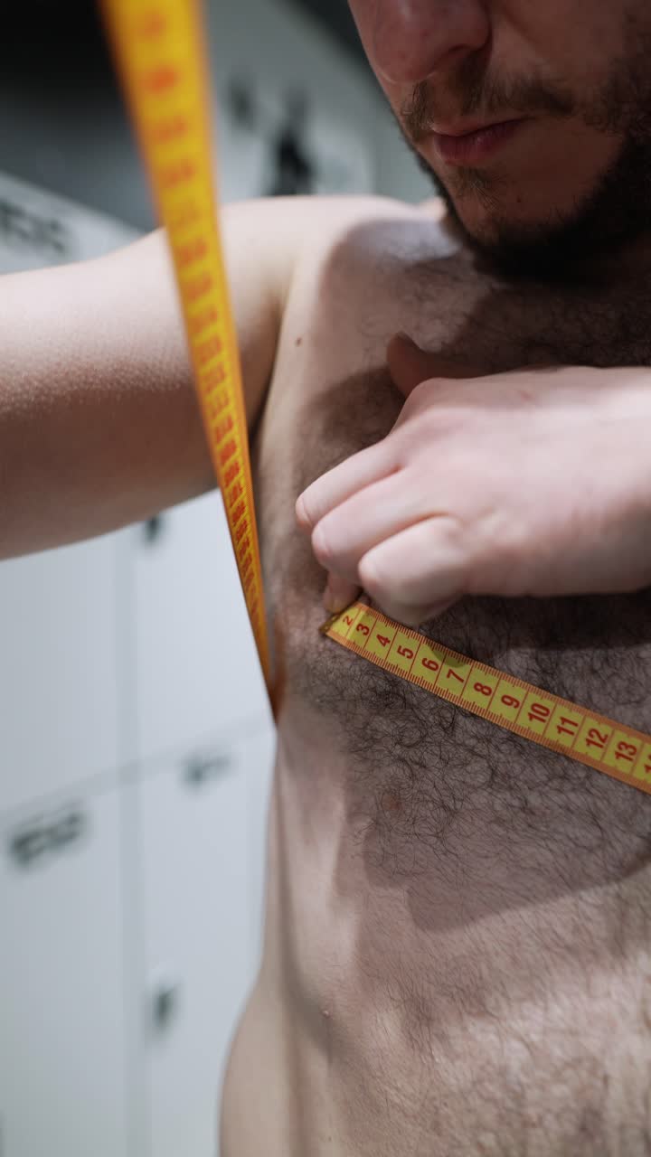 Man measuring his chest in a locker room