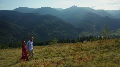 joyful lovers in mountains against amazing woods pikes background