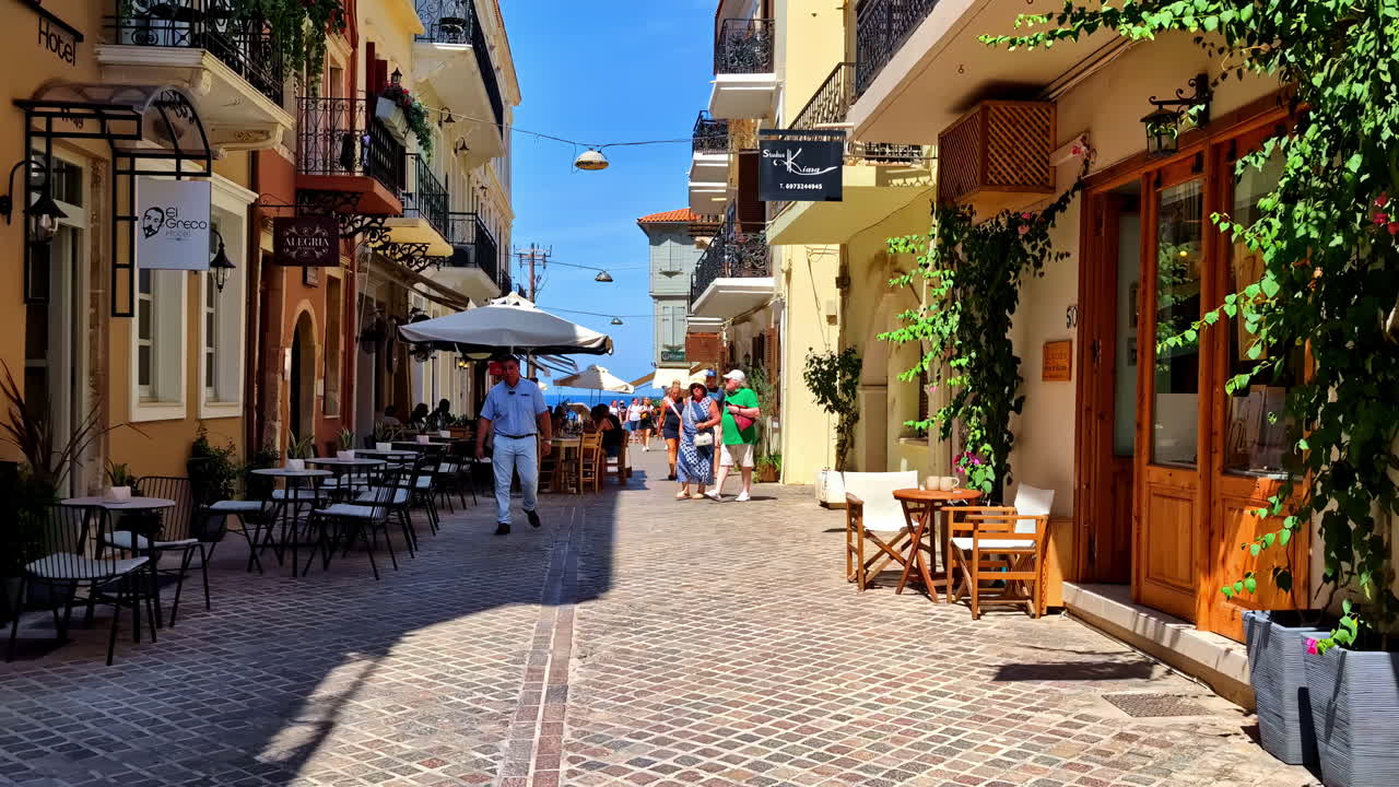 POV shot walking through Mediterranean beach restaurants in the tourist city of Chania Greece, sunny summer