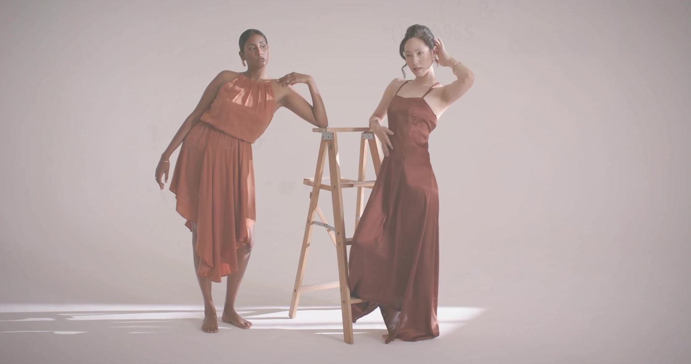 Due modelli che entrano e si appoggiano a una scala in studio per un servizio fotografico di moda digitale con codice fluttuante.