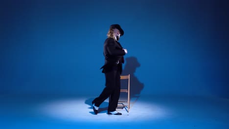 man in suit and hat performing on a blue background