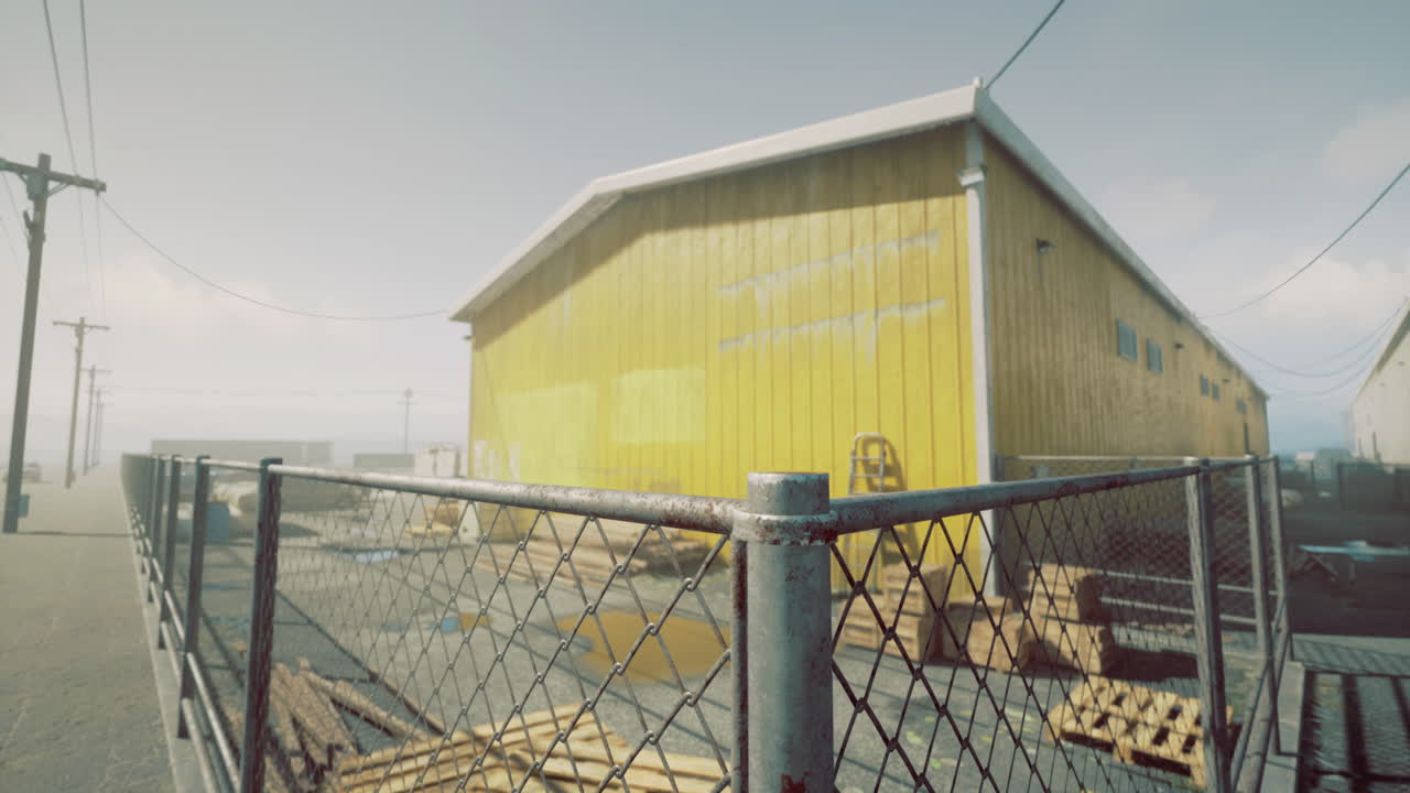 Bright yellow building surrounded by a fence in a coastal area during daytime