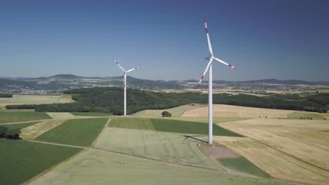 dolly aéreo en turbinas de molinos de viento en campos agrícolas durante el día generando energía renovable limpia para el desarrollo sostenible