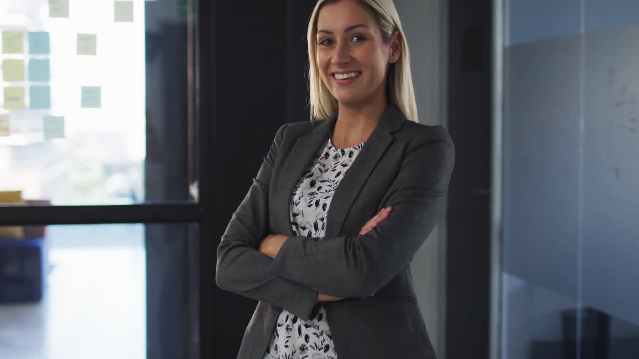 retrato de una mujer de negocios caucásica con los brazos cruzados sonriendo mirando a la cámara