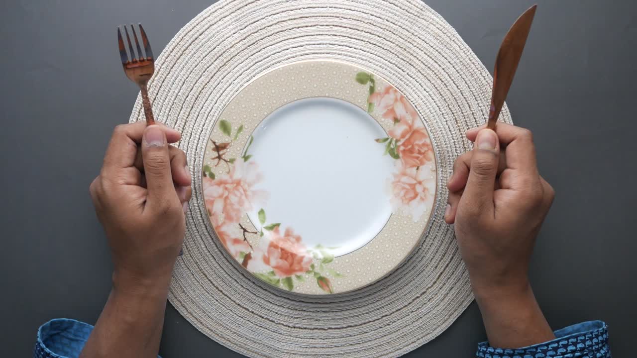 나무 테이블 에 빈 접시 를 들고 식구 를 들고 있는 손