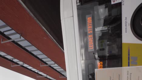 Vertical-shot-of-bus-with-passengers-arriving-at-Leuven-station,-Belgium---Portrait-mode