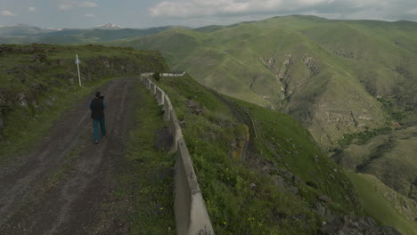 nómada solitario vagando por la carretera de montaña, rodeado de un paisaje impresionante