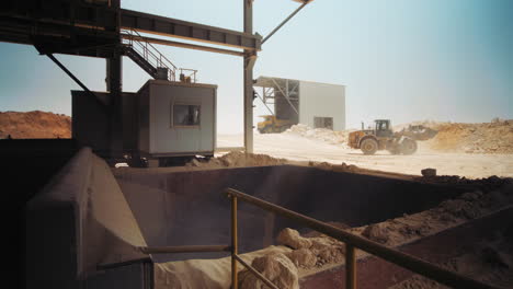 loader working at sand area. wide shot. loading and dumping sand into a mill, industrial machinery at sand quarry, 4k footage