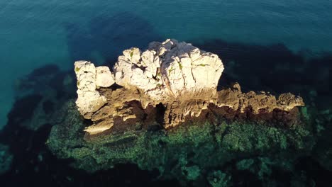 vuelo aéreo sobre aguas cristalinas de mar turquesa de cerdeña, volando hacia la formación de roca blanca, puesta de sol