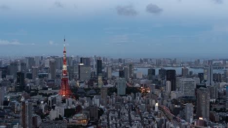 beautiful 4k timelapse over tokyo cityscape at dusk illumination lighting up tokyo tower - panning shot