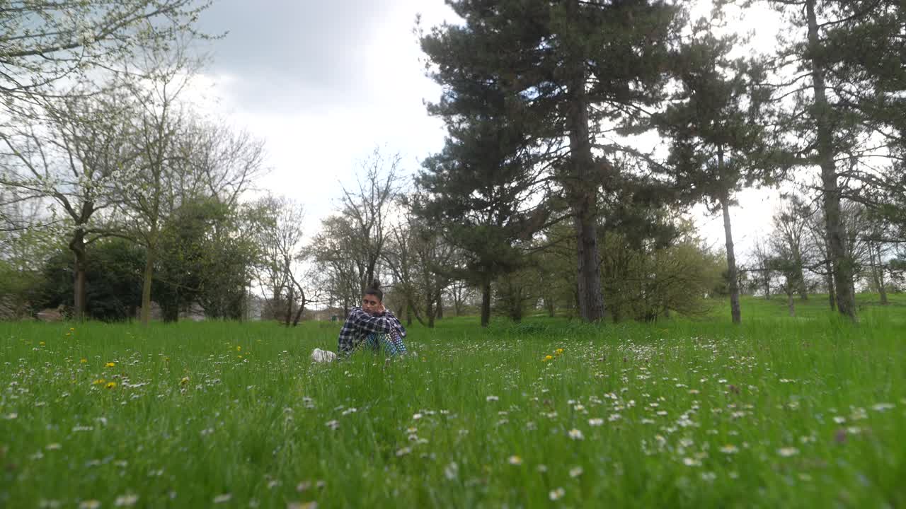 Woman Sitting in a Park Field