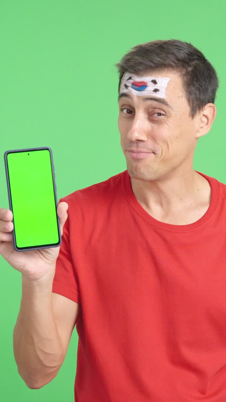 South Korea supporter looking at his mobile smiling and showing it