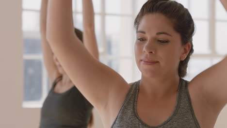 retrato de una joven hispana embarazada en clase de yoga practicando pose de guerrero disfrutando de un estilo de vida saludable haciendo ejercicio en grupo en el gimnasio