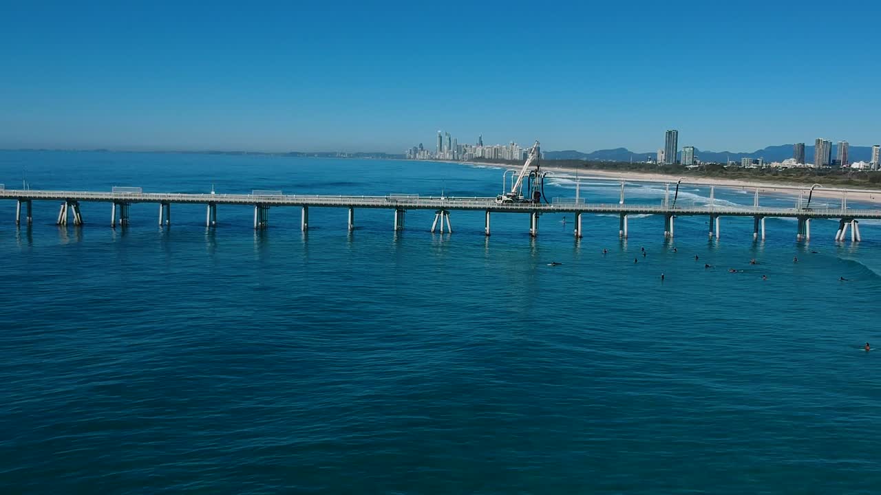 골드 코스트 스카이라인을 배경으로 서핑하는 사람들