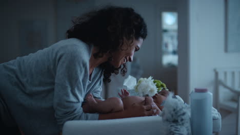 mother caring for baby on changing table happy mom playfully soothing toddler at night nurturing her child at home