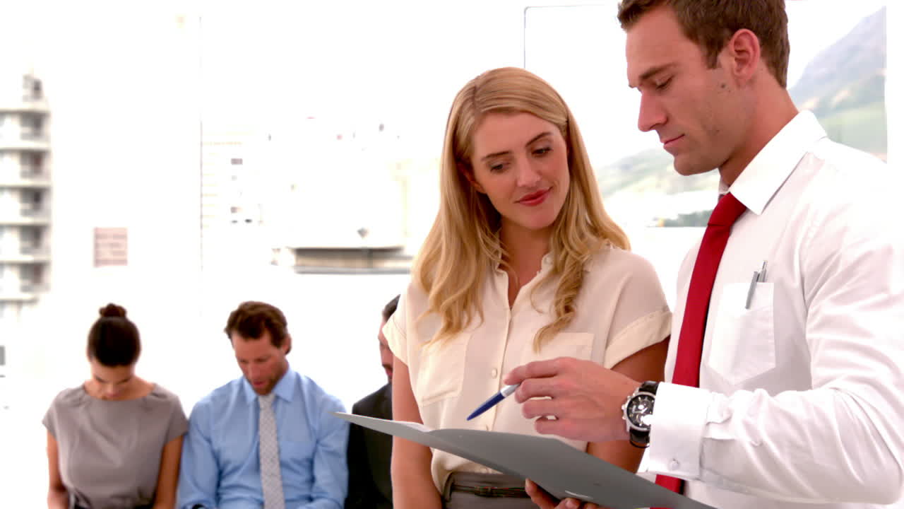 бизнесмен, разговаривающий с заявителем перед другими заявителями