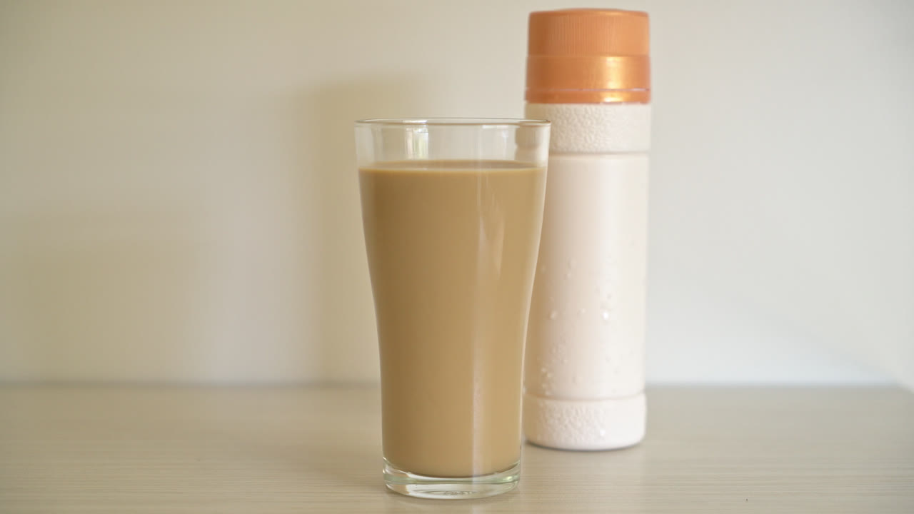 bicchiere di caffè latte con bottiglie di caffè pronte da bere sul tavolo