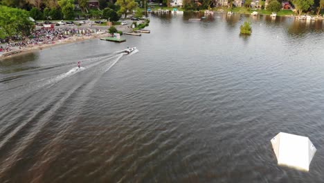 As-the-sun-is-setting-over-a-samll-town-in-western-Wisconsin,-waterskier-are-Performing-their-weekly-show-it-in-front-of-a-packed-audience-on-the-beach