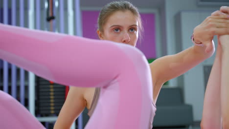 entrenador de fitness centrado supervisa la sesión de entrenamiento abdominal con la dama de rosa, primer plano en el entrenamiento en el entorno del gimnasio, motivación de fitness y orientación