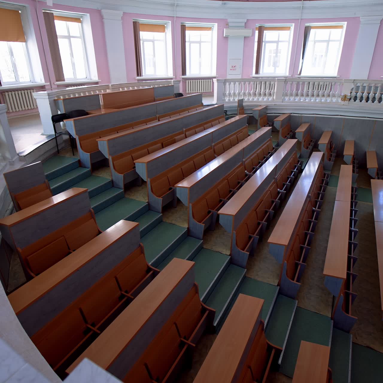 Lecture hall in the university. Panoramic view of educational center indoors. Large auditorium with empty desks during pandemic