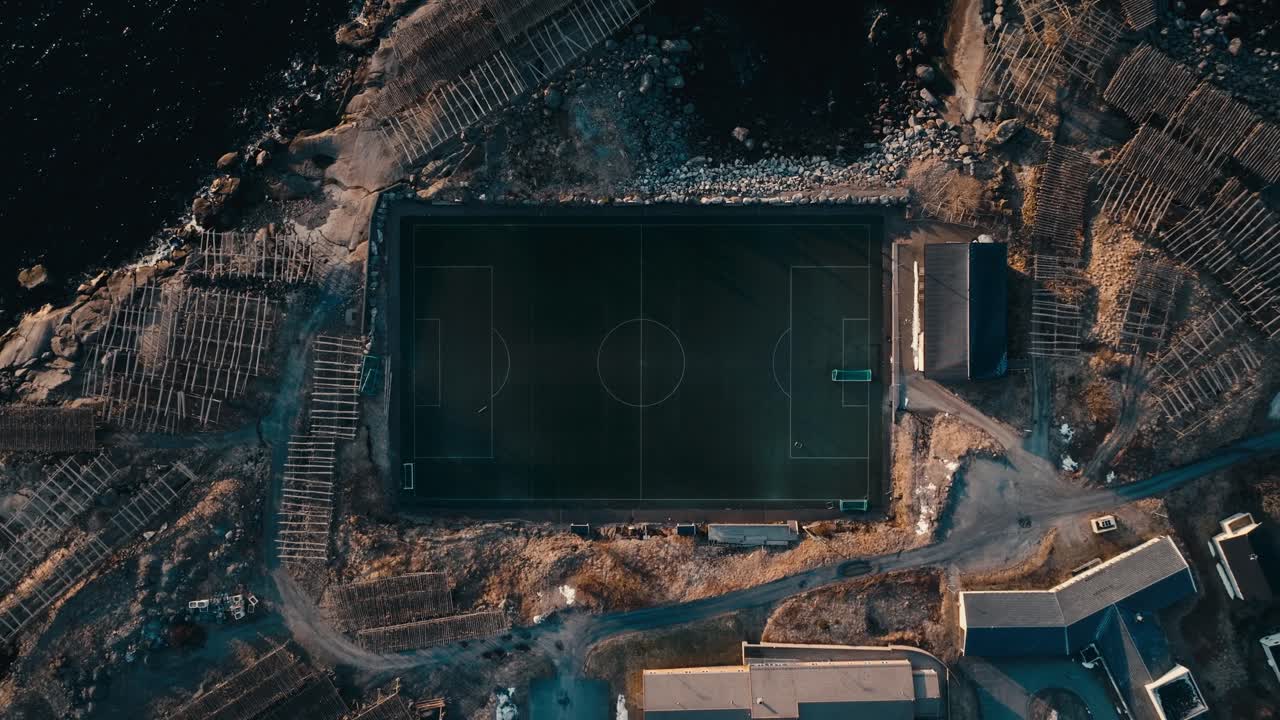 Overhead View of Soccer Field In Reine Village, Norway. - aerial ascend shot