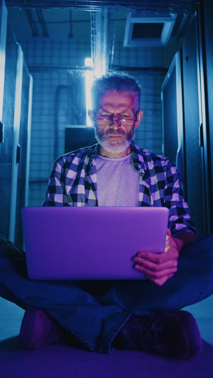 Technician working in a data center at night