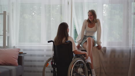 mujer rubia alegre habla con su novia tocando la barbilla
