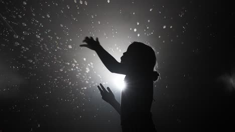 child playing with bubbles in the dark