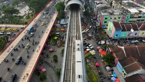 Tren-Público-Entrando-En-La-Estación-De-Tren-De-Ampera-En-La-Ciudad-De-Palembang,-Vista-Aérea