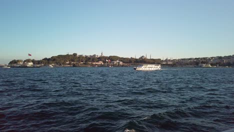 evening, cinematic slow-mo, a mesmerizing view of sarayburnu from a ferry on the golden horn in istanbul
