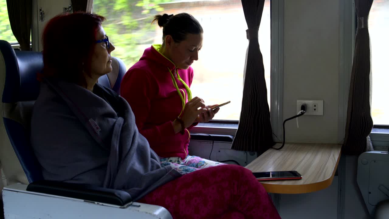 las mujeres suben al tren y usan teléfonos inteligentes