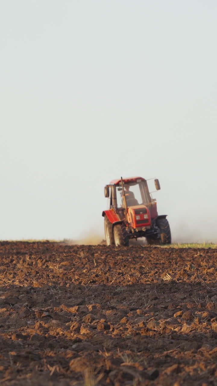 Farmer working in the field. Farmer in tractor preparing land with seedbed cultivator