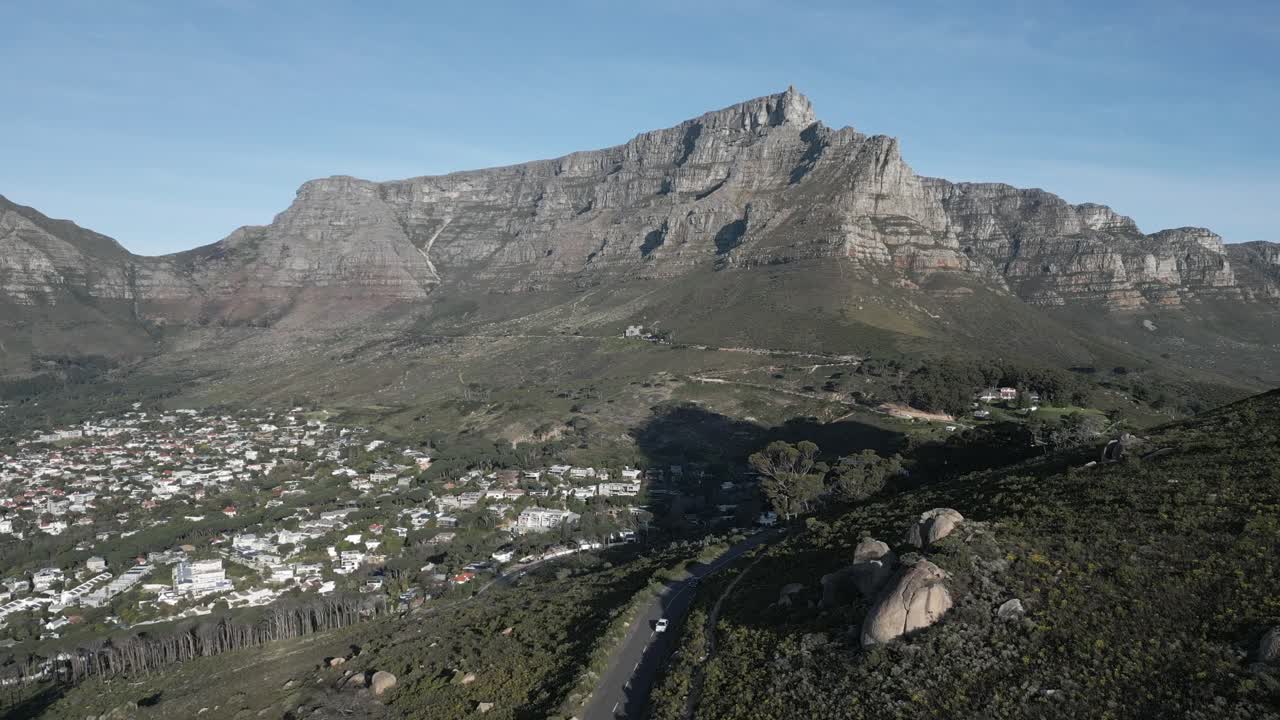 Ripresa aerea con drone di auto che percorrono le imponenti montagne di Città del Capo.