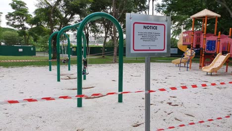 children's playground with barrier tape and warning signs during covid-19 lockdown in a public park in singapore, asia