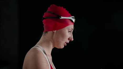 woman in a swim cap and goggles getting ready for a swim