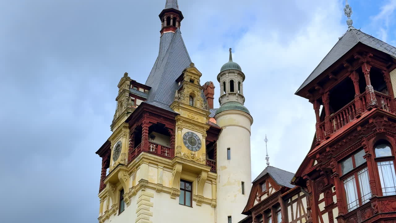 Sinaia, Romania, 17 July 2025: Architectural details of Peles Castle tower in Romania. Close-up of tower with spire and clock of Peles Castle in Sinaia Romania showing detailed ornament and stonework