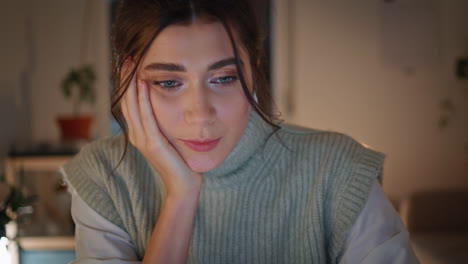 tarde freelancer videocalling portátil en el apartamento de primer plano. mujer buscando computadora
