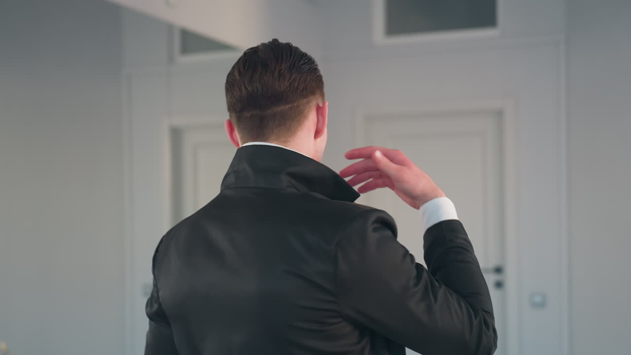 confident man in black coat and white shirt pauses with hand on chin turning to walk toward apple on stool gazing at it thoughtfully in bright modern interior setting with subtle reflective ambiance